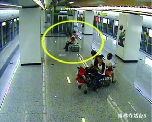 男子抱小孩在站台上小便