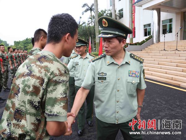 图为武警海南省总队政委雷万军与老兵握手话别.
