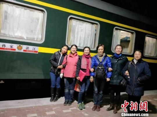 图为参加专列的游客在火车前合影。史轶夫　摄