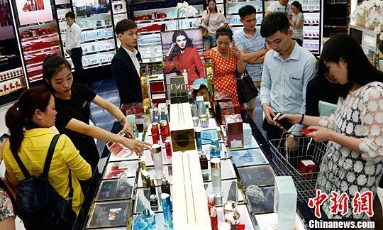 资料图：海南三亚游客在三亚国际免税城购买免税商品。中新社记者 尹海明 摄