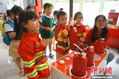 资料图：儿童节孩子们穿上迷你消防服，体验模拟灭火。　韩章云 摄