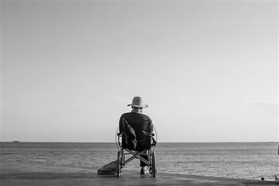 1月15日，海南三亚的一处海滩上，一名老人正坐在轮椅上看海景。 本报记者王伟伟 摄