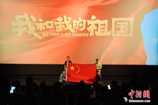 当地时间10月3日晚，德国柏林CinemaxX影院一场加映包场《我和我的祖国》开映前，观影的留学生和本地华人与中国国旗合影。中新社记者 彭大伟 摄