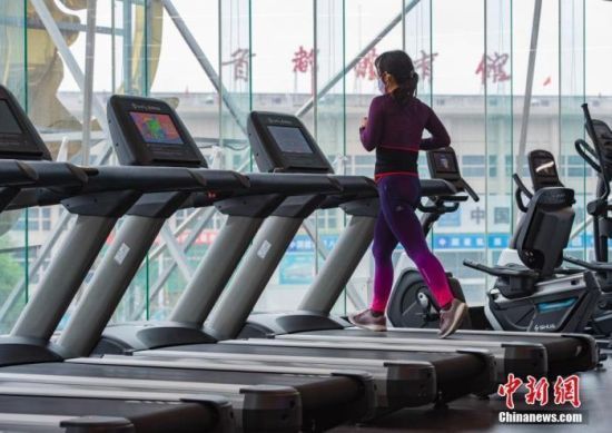 资料图：一位市民在一家健身房内跑步锻炼。中新社记者 侯宇 摄