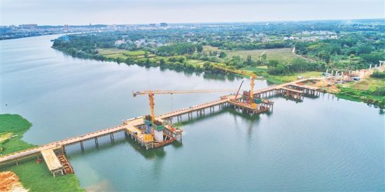 位于国道G360定安至澄迈段公路项目南渡江特大桥施工现场，设备林立、工人铆足干劲施工。海南日报记者 封烁 摄
