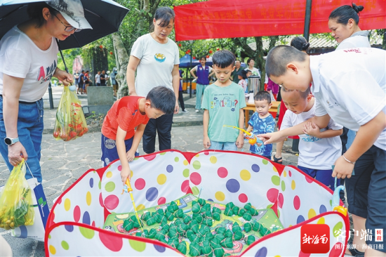 六月十三日，在海口火山口公园，家长带孩子体验钓“粽子”游戏。海南日报记者 李天平 摄