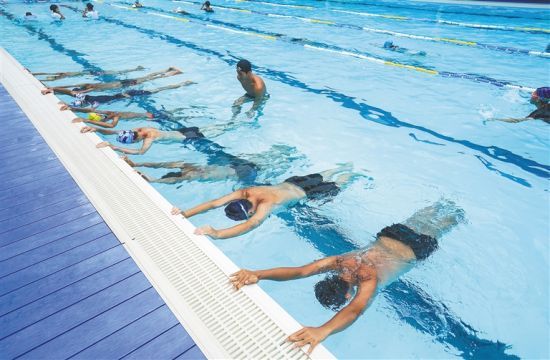 7月22日,三亚中小学生在海南中学三亚学校游泳池参加暑期游泳培训。武威 摄
