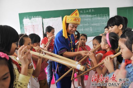 图为黎族竹木器乐国家级传承人黄照安到保亭小学教授小学生吹鼻箫。黄青文 摄