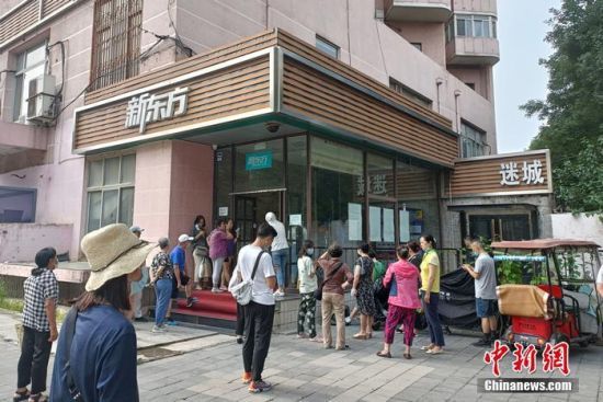 新东方门口，正在等待孩子下课的家长们。中新网 左雨晴 摄