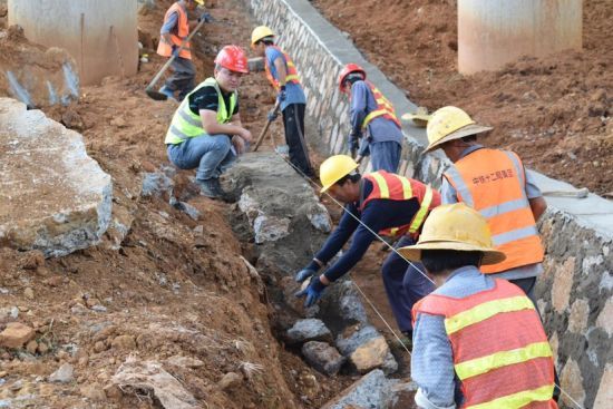 工人利用放线施工办法进行桥下浆砌边沟施工。