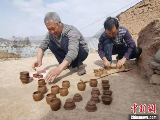 2022年3月，甘肃省天水市武山县洛门镇赵碾村张家兄弟展示手工陶器。（资料图）　薛小瑞　摄