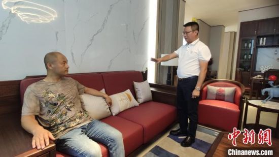  陈礼豪（右）在家具批发城接待顾客。　林士杰　摄