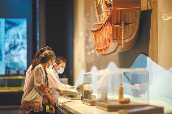 7月16日，在中国（海南）南海博物馆，家长带着孩子参观展品。袁琛 摄