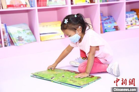 图为在第二十届北京国际图书节儿童光影阅读区阅读的女孩。　第二十届北京国际图书节组委会供图