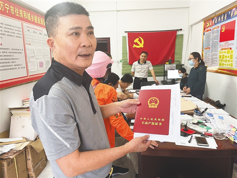 万宁市住建局工作人员周广生为住户办不动产权证书。 本报记者 张惠宁 摄