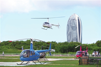 观光直升机在凤凰岛停机坪上频频起降,八方游客在空中饱览三亚湾美景。本报记者 李学仕 摄