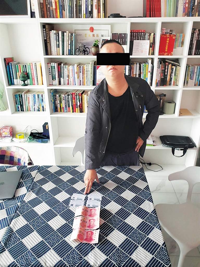 戚某指认还未使用的赃款。 （海口海岸警察供图）