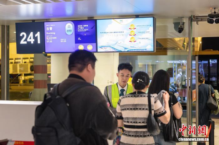 11月15日,乘坐海口至古晋直飞航班的游客在登机口检票。 (海口美兰国际机场供图)