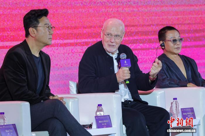 图为意大利电影制片人、学者、策展人马可·穆勒(中)在第七届海南岛国际电影节“金椰奖”国际评委见面会上回答媒体记者提问。 中新网记者 骆云飞 摄