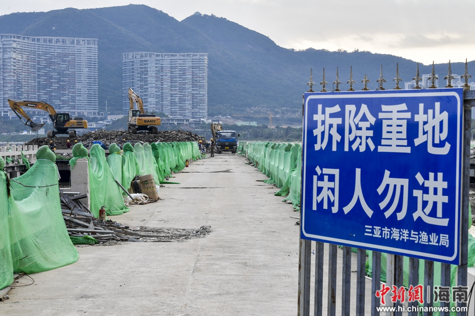 图为三亚执法部门正在对"海上餐厅"进行拆除作业,入口处设有警示牌.