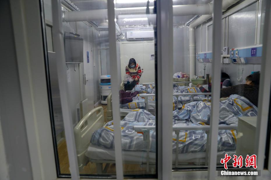 火神山医院感染二科一病区隔离病房内一位治愈患者整理衣物即将出院