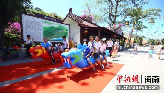 端午节：游客在三亚南山文化旅游区参加旱地龙舟赛。 陈文武摄