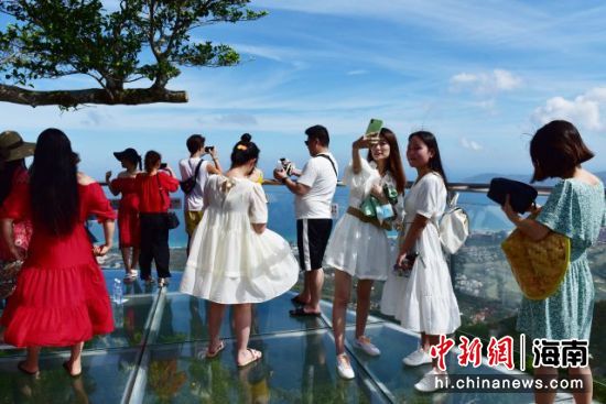 盛夏时节，游客在亚龙湾热带天堂森林旅游区登高望远。（黄庆优摄）