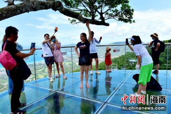 盛夏时节，游客在亚龙湾热带天堂森林旅游区登高望远。（黄庆优摄）