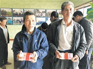 来自新坡镇、龙泉镇的贫困户领到分红。海口日报记者 邝晓霞 摄