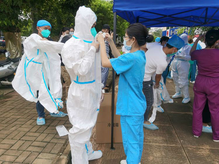 医护人员上岗前互相检查防护服穿戴工作,确保自身安全的情况下全力以