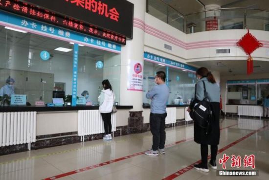 资料图：民众在医院门诊大厅排队挂号。中新社记者 杨迪 摄