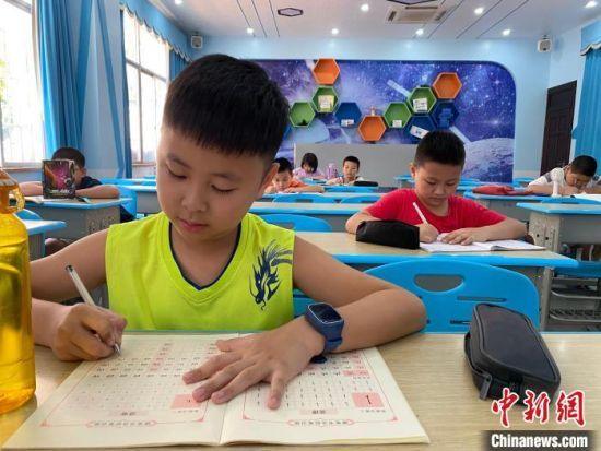  海口市第二十六小学的暑期托管班，学生正在写字。凌楠 摄