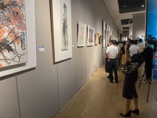 展览现场，美术作品吸引观众驻足欣赏并拍照。陈望 摄