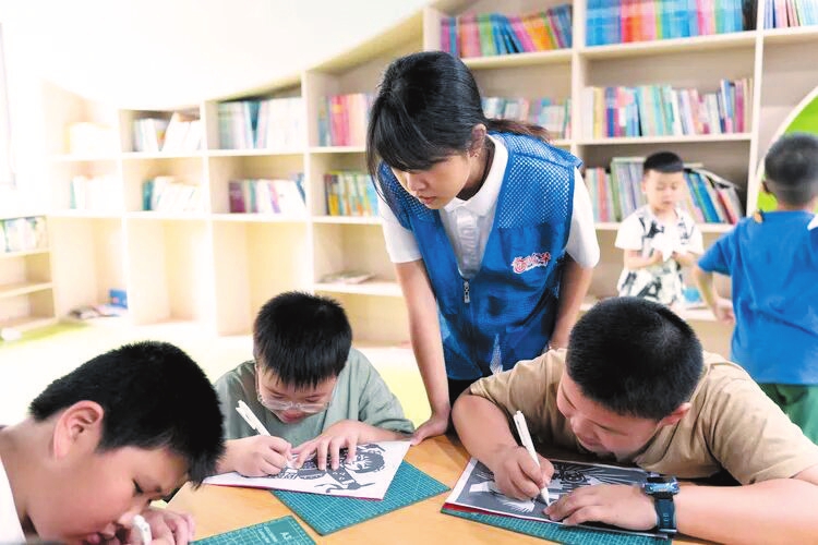 活动中,孩子们在志愿者引导下进行禁毒主题剪纸体验。