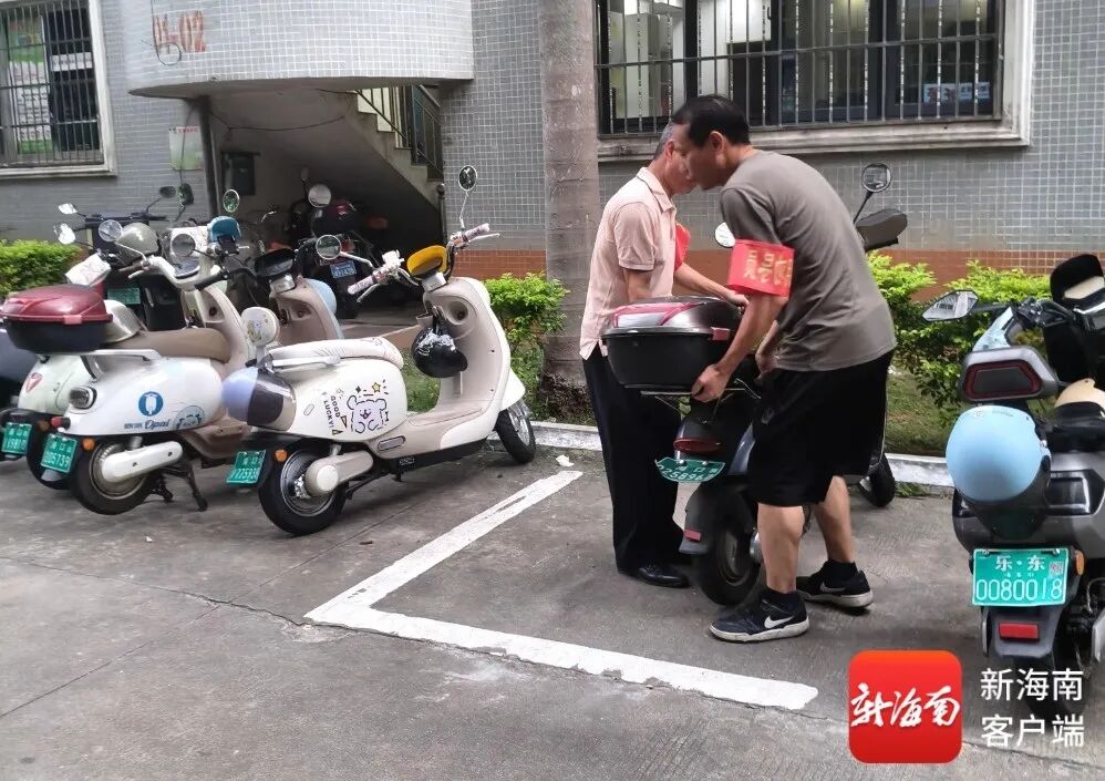 工作人员将主干道、消防通道内的违规电动自行车挪移规整至指定区域。秀英区供图