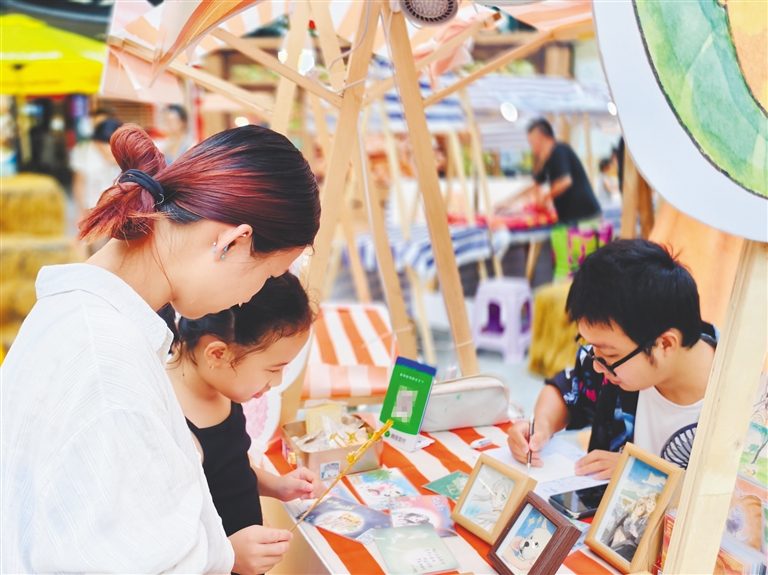 10月3日,海口日月广场一位手绘文创摊位摊主为顾客作画。海南日报全媒体记者 陈明艳 摄
