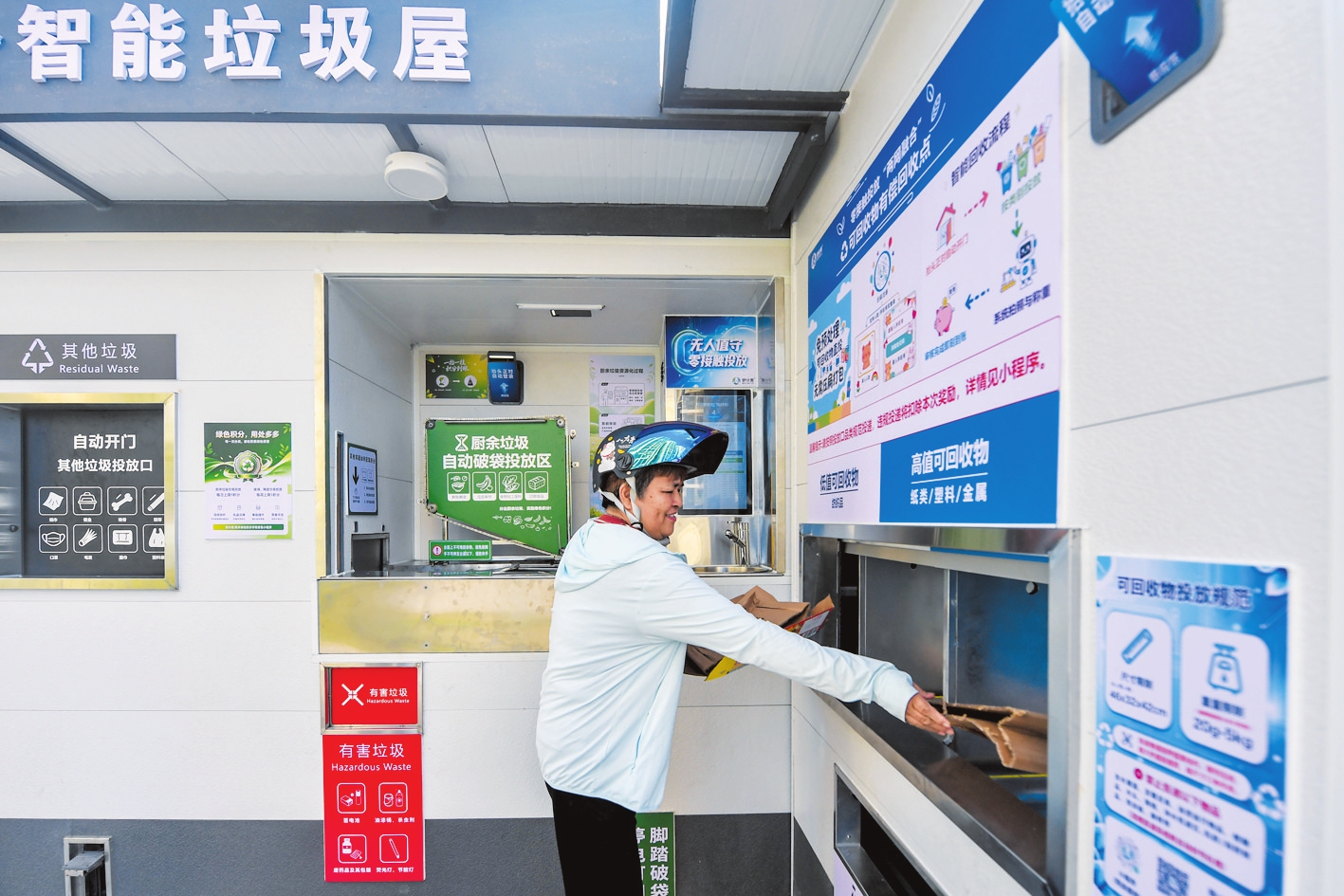 10月13日,在秀英区荣锦花园小区,居民将纸板投入智能垃圾屋。本报记者苏弼坤摄