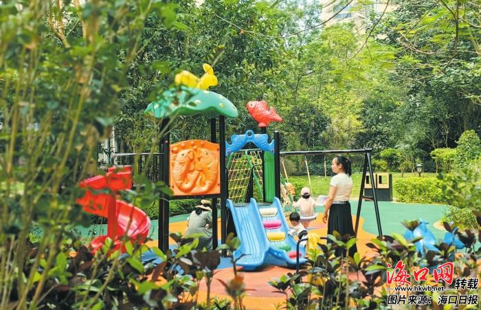 中海锦城小区内，孩子在家长的守护下玩滑梯，在绿荫环绕中，温馨和谐的气息扑面而来。记者 康登淋 摄